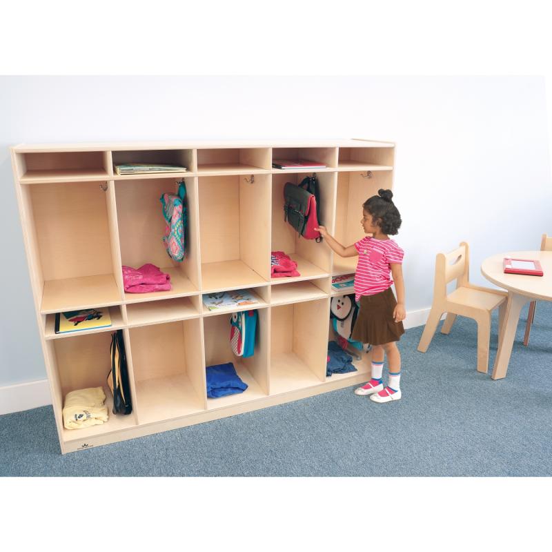 Child interacting with a wooden storage unit in a classroom setting