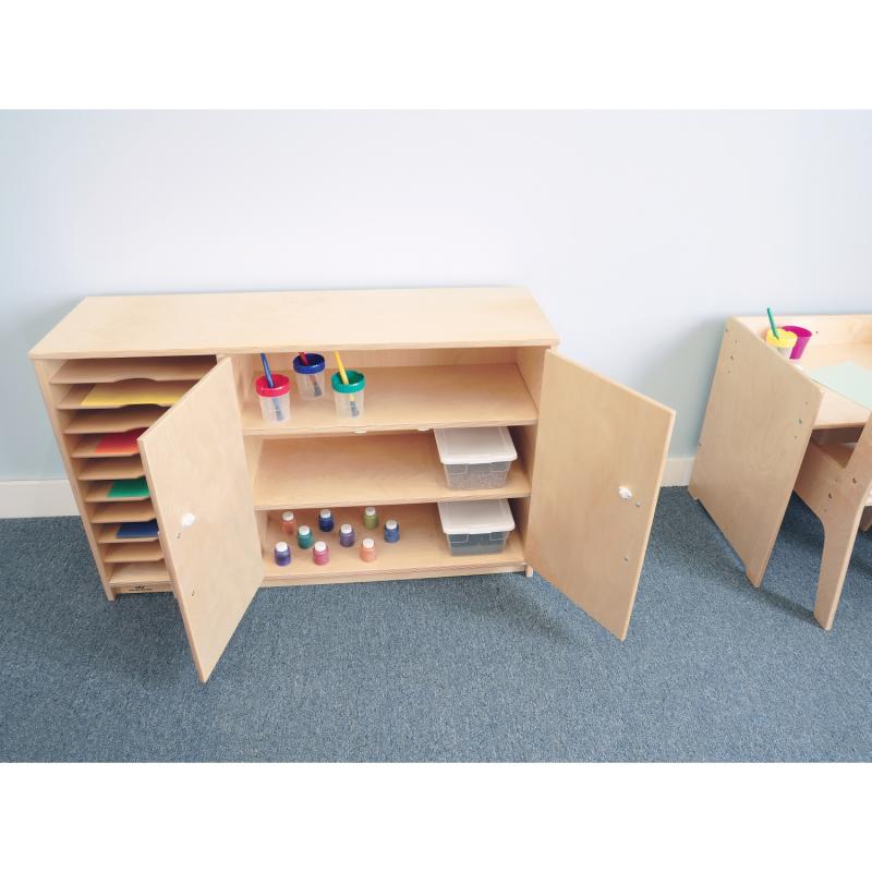 Wooden storage cabinet with open doors on a blue carpeted floor.