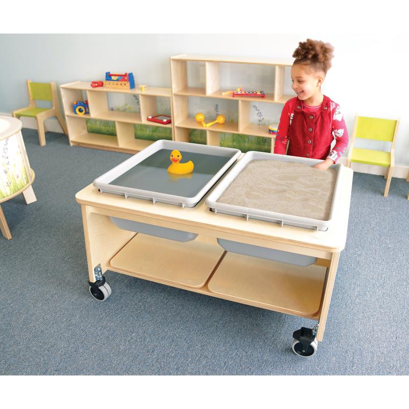 Child playing with a sensory table in a classroom setting